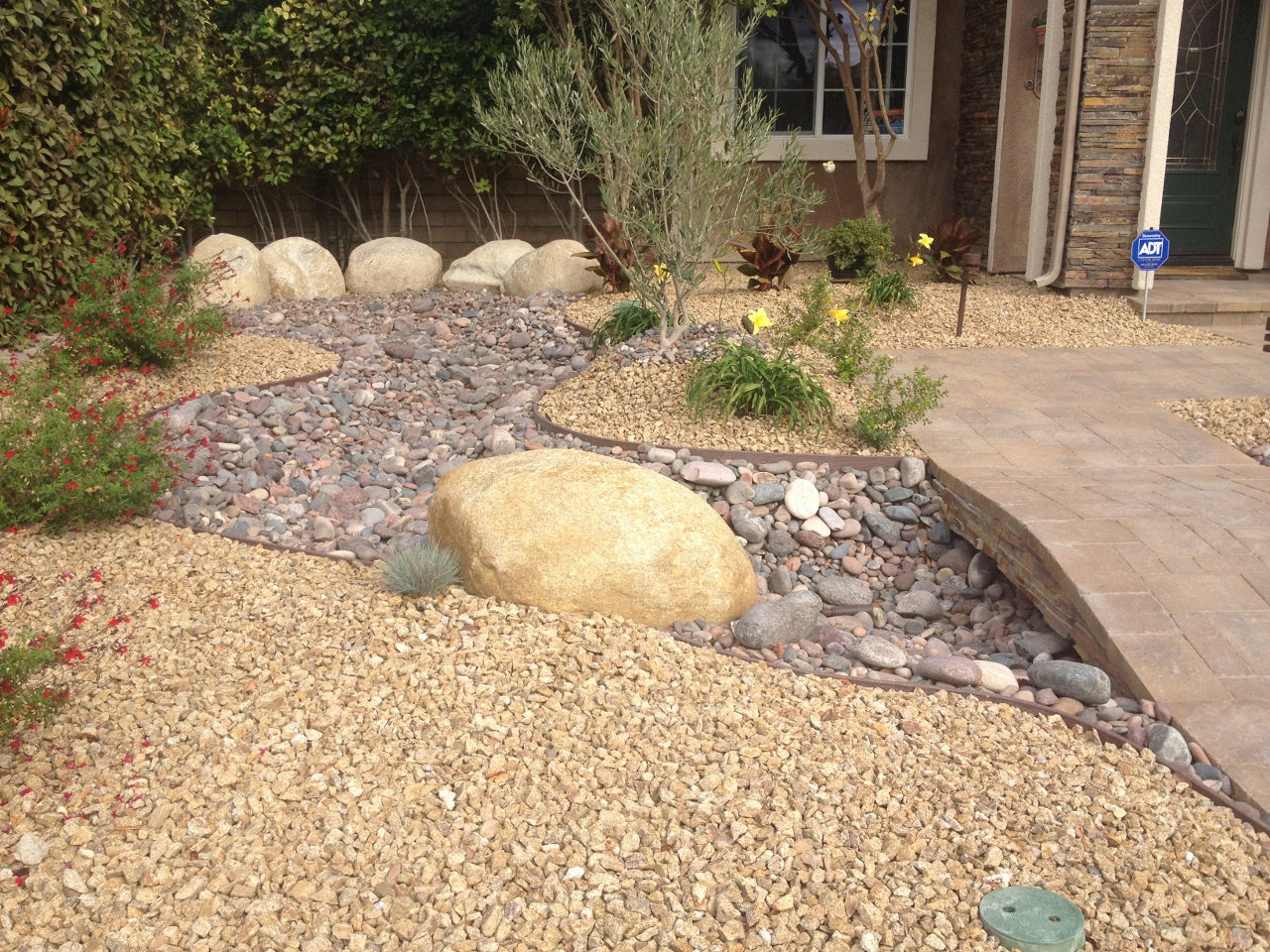 Desert front yard with gold gravel and a river-rock dry creek