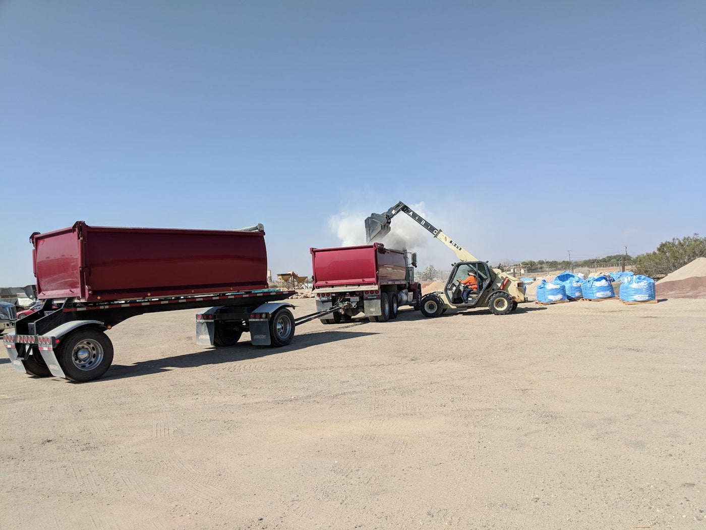Earth Stone Rock delivery truck and transfer trailer loaded with bulk material