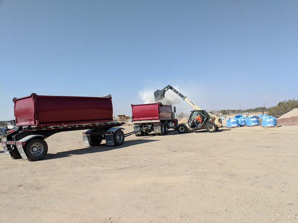 Earth Stone Rock delivery truck and transfer trailer loaded with bulk material