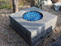 Black marble boulder fire pit with blue fire glass