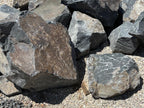 Black Hawk boulders for dry creek beds and erosion control, in mixed charcoal and rust tones