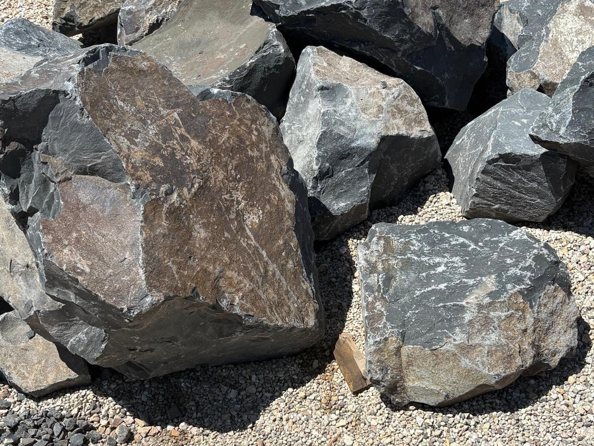 Black Hawk boulders for dry creek beds and erosion control, in mixed charcoal and rust tones