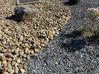 Black n Silver Rock 1 inch installed beside tan river rock cobble and a dark accent boulder