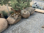 Moss rock boulders on gravel at the yard, granite with moss and lichen