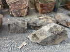 Weathered granite moss rock boulders laid out on gravel